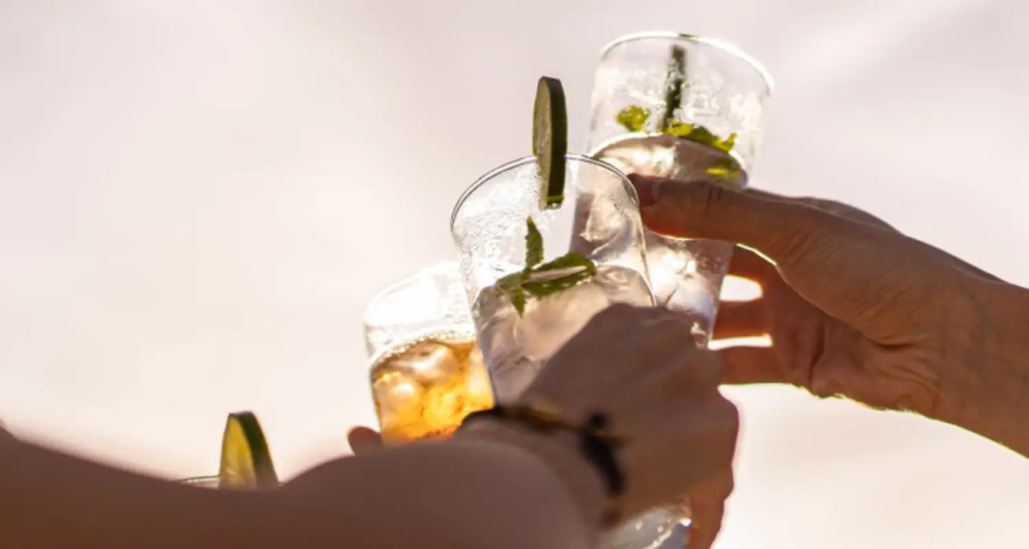 Glasses with cocktails come together in a cheers moment