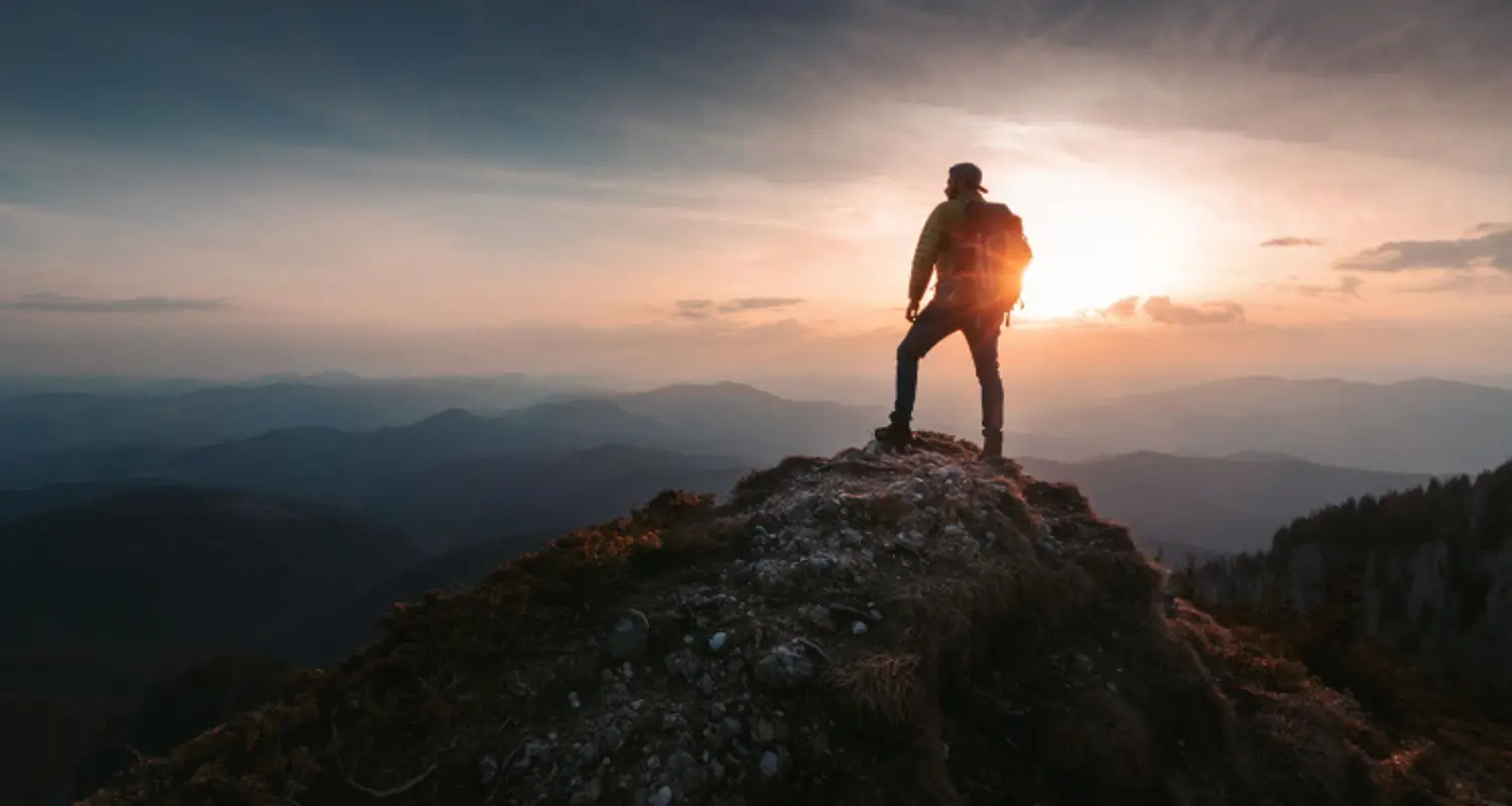 Inspiring picture of a person summiting a mountain top