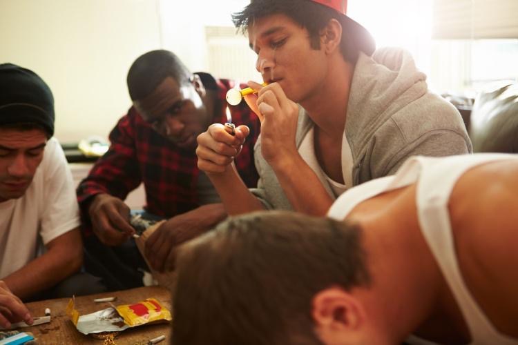 Group of young men smoking crack cocaine together